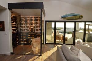 Modern home glass wine cellar with glass door, glass walls, and ambient lighting