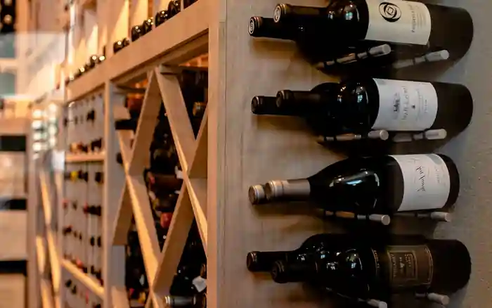 close up picture of wooden wine racks with metal wine pegs at the side.