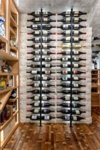 Stone wall with metal wine racks in modern wine cellar
