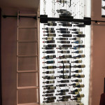 A library-style rolling ladder looks beautiful and makes it easy to reach the bottles in the higher compartments.