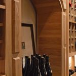 Upon entering this wine cellar, you'll see this wooden arch on the right. It has a relatively high ceiling height within our wooden wine racks, so the owner could also display his magnum bottles, champagne bottles, gins, burgundy, etc.