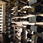 We incorporated different bottle display orientations in this glass wine room. You'll notice that some bottles are displayed label first, while other are displayed cork first.