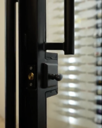 9 - A single black metal door handle with lock and magnet is used in this modern wine cellar. Modern wine closet under the stairs with metal door handle