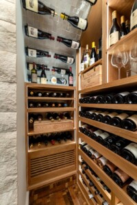 8 - Wooden racks can safeguard bottles and cooling units. Can you guess where this modern wine cellar's cooling unit is, in the picture? modern wine cellar tiled ceilings